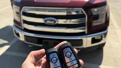 Two car key fobs held beside a truck